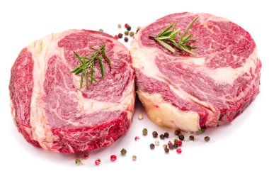 Beyaz arka planda pişmeye hazır baharatlı ve otlu çiğ biftek..