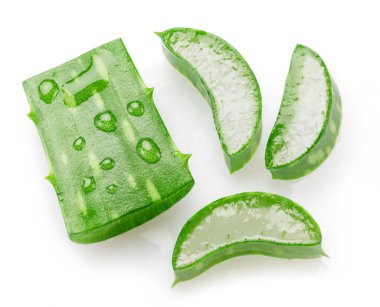 Beyaz arka planda izole edilmiş su damlalarıyla kaplı taze aloe vera yaprağı kesikleri. Üst görünüm.
