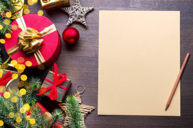 Noel süsü, hediye kutuları ve Noel Baba 'ya tahta masaya mektup yazmak için boş bir kağıt. Üst görünüm.