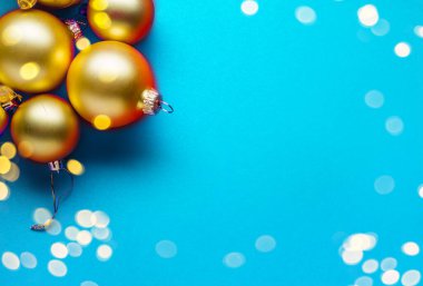 Mavi arka planda bir çerçeve olarak bulanık altın noel süslemesi. Uzan..