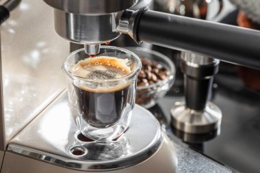 Otomatik kahve makinesi. Kahve fincanına yakın çekim kahve dolduruyorum.. 