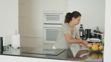 Kadın mutfak tezgahını, elektrikli sobayı ya da elektrikli ocağı temizliyor. Yavaş çekim görüntüleri.