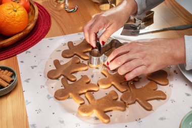 Noel kurabiyeleri yapıyor - zencefilli kurabiye adamlar, kadın kalıplarla kurabiyeleri kesiyor.