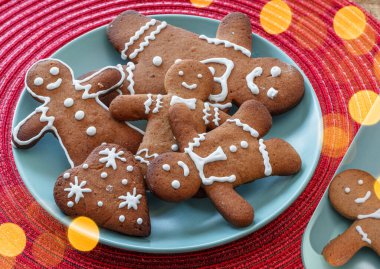 Gingerbread men, christmas cookies decorated with royal icing on blue plate, top view. clipart