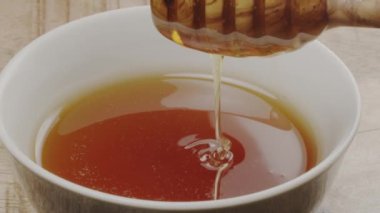 Bal damlaları yavaşça ahşap bal kabından bal kabına akıyor, yakın çekim, yavaş çekim.. 