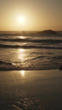 Atlantik Okyanusu 'nun Adraga plajı gün batımında, Sintra Portekiz. Güneş, su yüzeyine parlak bir yol ile yansıdı. Yavaş çekim videosu.