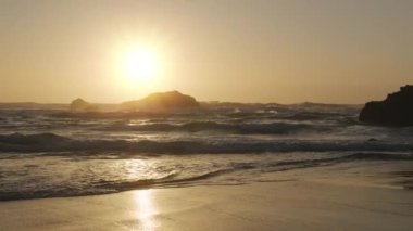 Atlantik Okyanusu 'nun Adraga plajı gün batımında, Sintra Portekiz. Güneş, su yüzeyine parlak bir yol ile yansıdı. Yavaş çekim videosu.