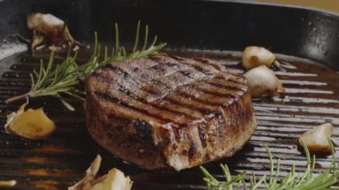 Tavada kızartılmış pirzola, lezzetli bir kabuk yaratmak için ateşte pişiyor.. 