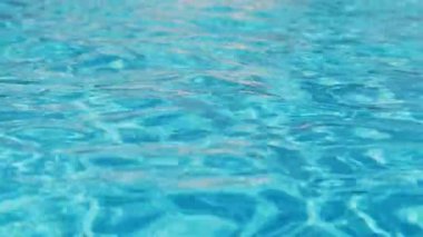 Havuzun suyunda dalgalanmalar; şeffaf; köpüklü; hareketli suyun davetkar yüzeyi; yukarıdan görünüm. Yavaş çekim ve döngülü video.