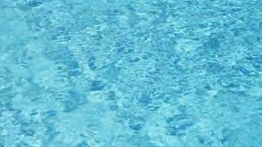 Havuzun suyunda dalgalanmalar; şeffaf; köpüklü; hareketli suyun davetkar yüzeyi; yukarıdan görünüm. Yavaş çekim ve döngülü video.