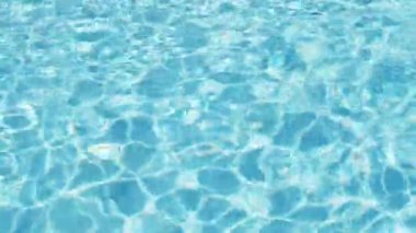 Havuzun suyunda dalgalanmalar; şeffaf; köpüklü; hareketli suyun davetkar yüzeyi; yukarıdan görünüm. Yavaş çekim ve döngülü video.