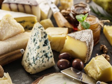 Tahta masadaki farklı peynir parçalarının çeşitleri. Yakın çekim...