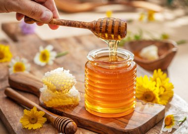 Cam kavanozda doğal organik bal, bal kovanı ve bal petekleri yakında. Doğal gıda geçmişi.