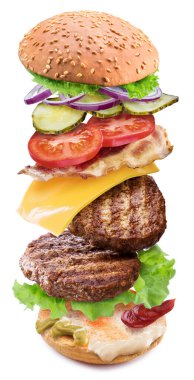 Beyaz arka planda havada süzülen sebzeli ve peynirli etli köfte burgeri. Dosya kırpma yolları içeriyor.