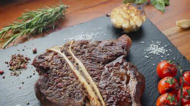 Biftek, otlu ve sarımsaklı servis panosuna yakın çekim. Üst görünüm.