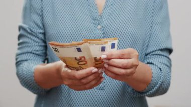 50 dolarlık banknotları yakından sayan tanınmayan bir kadın. Eller yukarı..