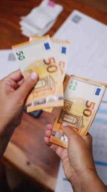 50 dolarlık banknotları yakından sayan tanınmayan bir kadın. Dikey video.