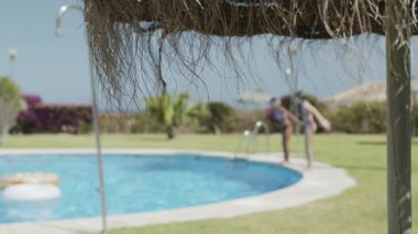 Genç kızlar tatilin tadını çıkarıyorlar; oynuyorlar ve havuza atlıyorlar.. 