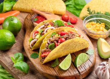 Tahta servis tahtasının yanında Meksika usulü et, tortilla ve limon dilimleri.. 