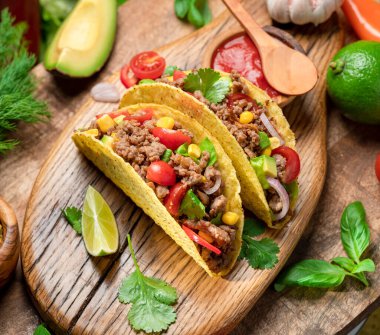 Tahta servis tahtasının yanında Meksika usulü et, tortilla ve limon dilimleri.. 