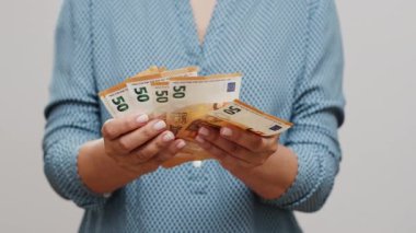 Cüzdanında ya da cüzdanında avro sayan tanınmamış bir kadın. 50 dolarlık banknotları sayıyorum..