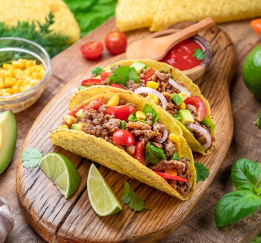 Tahta servis tahtasının yanında Meksika usulü et, tortilla ve limon dilimleri.. 