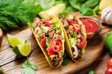 Tahta servis tahtasının yanında Meksika usulü et, tortilla ve limon dilimleri.. 