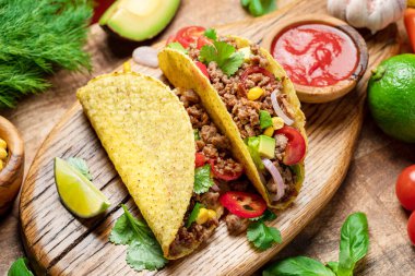 Tahta servis tahtasının yanında Meksika usulü et, tortilla ve limon dilimleri.. 