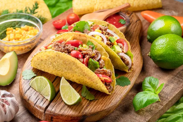 Tahta servis tahtasının yanında Meksika usulü et, tortilla ve limon dilimleri.. 