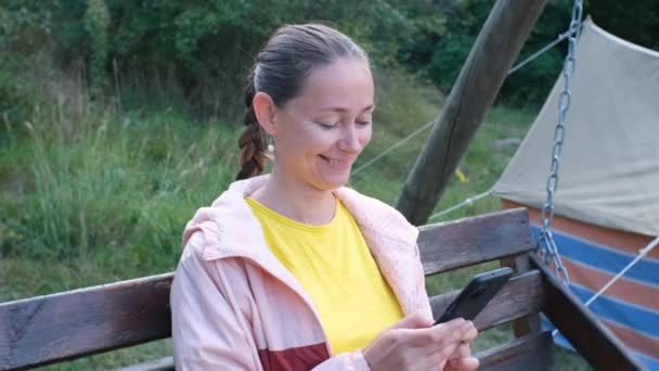 Wanita Kaukasia Paruh Baya Yang Ceria Bersantai Dengan Smartphone Tangannya — Stok Video