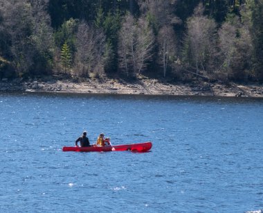 Schluchsee, Baden-Wutemberg, Almanya - 04.06.2024: Mavi gölde kano ve kano süren aile 