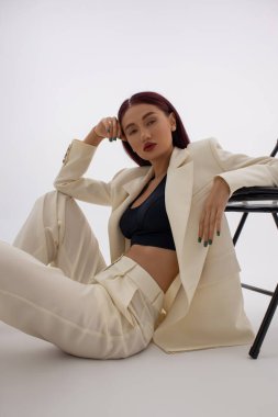 Güzel ve seksi bir kadın klasik bir takım elbise içinde izole edilmiş stüdyo çekimi.