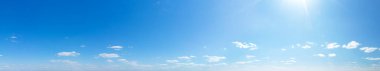 Mavi Gökyüzü arka planında küçük bulutlar var. Panorama arkaplanı