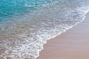 Kumlu sahilde yumuşak deniz dalgası. Arka plan.