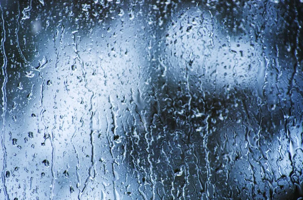 雨はボケを背景に窓ガラス面に落ちる — ストック写真