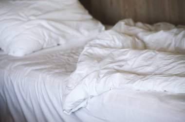Yatak odasındaki beyaz yastıklar beyaz yatakta. Otel servisi.