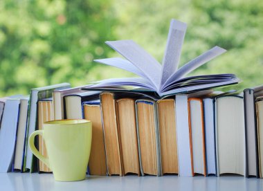 Masada kitap ve bardak yığını var.