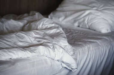 Yatak odasındaki beyaz yastıklar beyaz yatakta. Otel servisi.