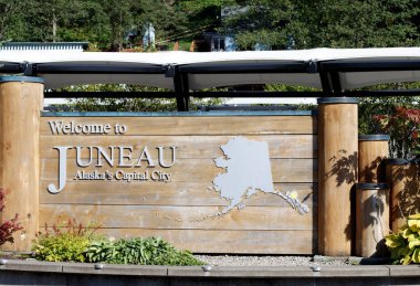 Juneau, AK, ABD - 17 Eylül 2024: Alaska 'nın başkenti Juneau' ya hoş geldin işareti, üzerinde odun destekli bir harita var.