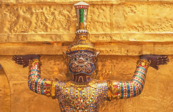 stock image Detail of one of the golden chedi, showing the supporting giants around the base, at the temple of the Emerald Buddha (Wat Phra Kaew), Bangkok, Thailand.