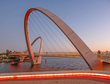 PERTH, AUSTRALYA - 20 HAZİRAN 2024: Batı Avustralya 'nın başkenti Perth' teki Elizabeth Quay Köprüsü 'nde gün batımını izleyen insanlar.