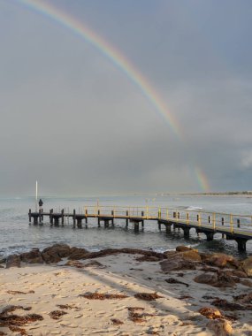 A rainbow over the jetty in winter at old Dunsborough in South-West Australia. clipart