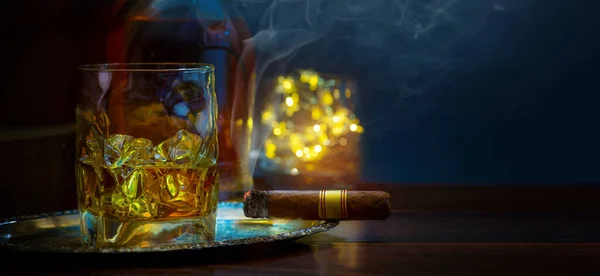 Szklankę Whisky Lodem Drewnianym Stole Kubańskie Cygaro Butelkę Whisky Zadymionej — Zdjęcie stockowe