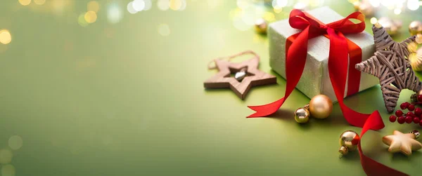 クリスマスグリーティングカードまたはクリスマスバナーデザイン 魔法のライトでライトグリーンの背景にギフトボックスと装飾品 — ストック写真