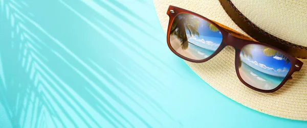 熱帯の海での休暇と夏の旅行のバナーコンセプト 砂浜のトロビックビーチとヤシの木を反映したパナマの帽子とサングラス — ストック写真