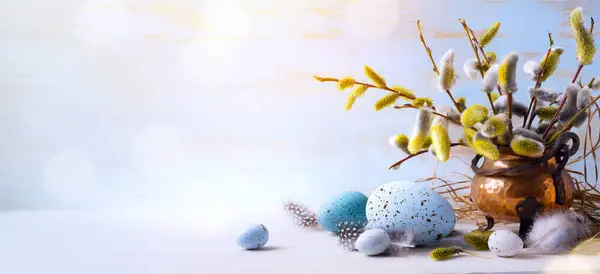 复活节快乐 复活节彩蛋和小枝花在蓝色桌背景 图库照片