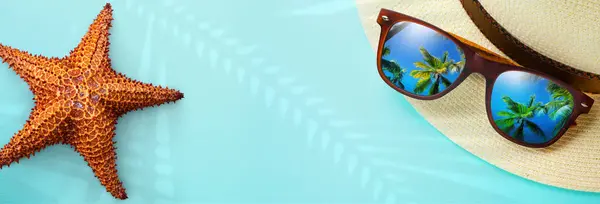 stock image concept vacation and summer travel banner. Happy holidays on sandy tropical sea beach. Panama hat and sunglasses with a reflection of the sandy trovic beach and palm trees