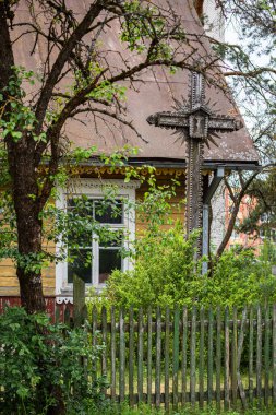 Litvanya 'nın Varena kentindeki geleneksel Litvanya ahşap evinin önünde antik bir tahta haç.