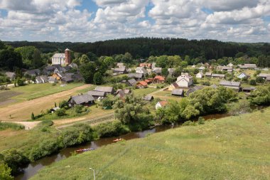 Lyduvenai, Litvanya - 15 Haziran 2024: Lyduvenai köyünün kilisesi ve Dubysa nehri manzaralı panoraması - Lyduvenai demiryolu köprüsünden manzara