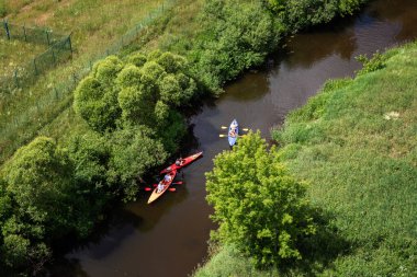 Lyduvenai, Lithuania - June 15, 2024: Kayaking in the Dubysa river - view from the Lyduvenai railway bridge. clipart